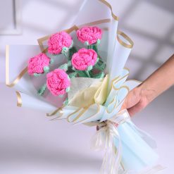 Five pink crochet roses wrapped in premium light blue paper