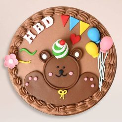 Top view of cute teddy birthday cake with party decorations